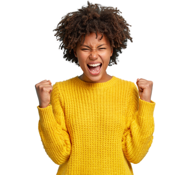 A woman wearing a yellow sweater holds her fists in excitement